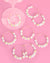 Set of pearl wine glass charms with various phrases on a pink background