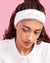 Woman wearing a white headband with 'Bride' text against a pink background