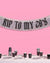 Decorative banner with 'Kiss to my 28's' text on a pink background, with a table set for a party below.