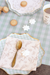 Decorative table setting with a spoon, napkin, and cookies on a checkered tablecloth.