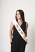 Woman wearing a sash with 'Happy 40!' text on a plain background