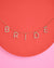 Necklace with 'BRIDE' letters on a pink and red background