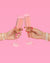 Two hands clinking champagne glasses against a pink background