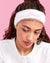 Woman wearing a white headband with 'Bride' text against a pink background