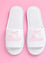 White slippers with 'Bride' text and pink bows on a pink background