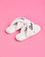 White slippers with 'Bride' embroidery on a pink and orange background