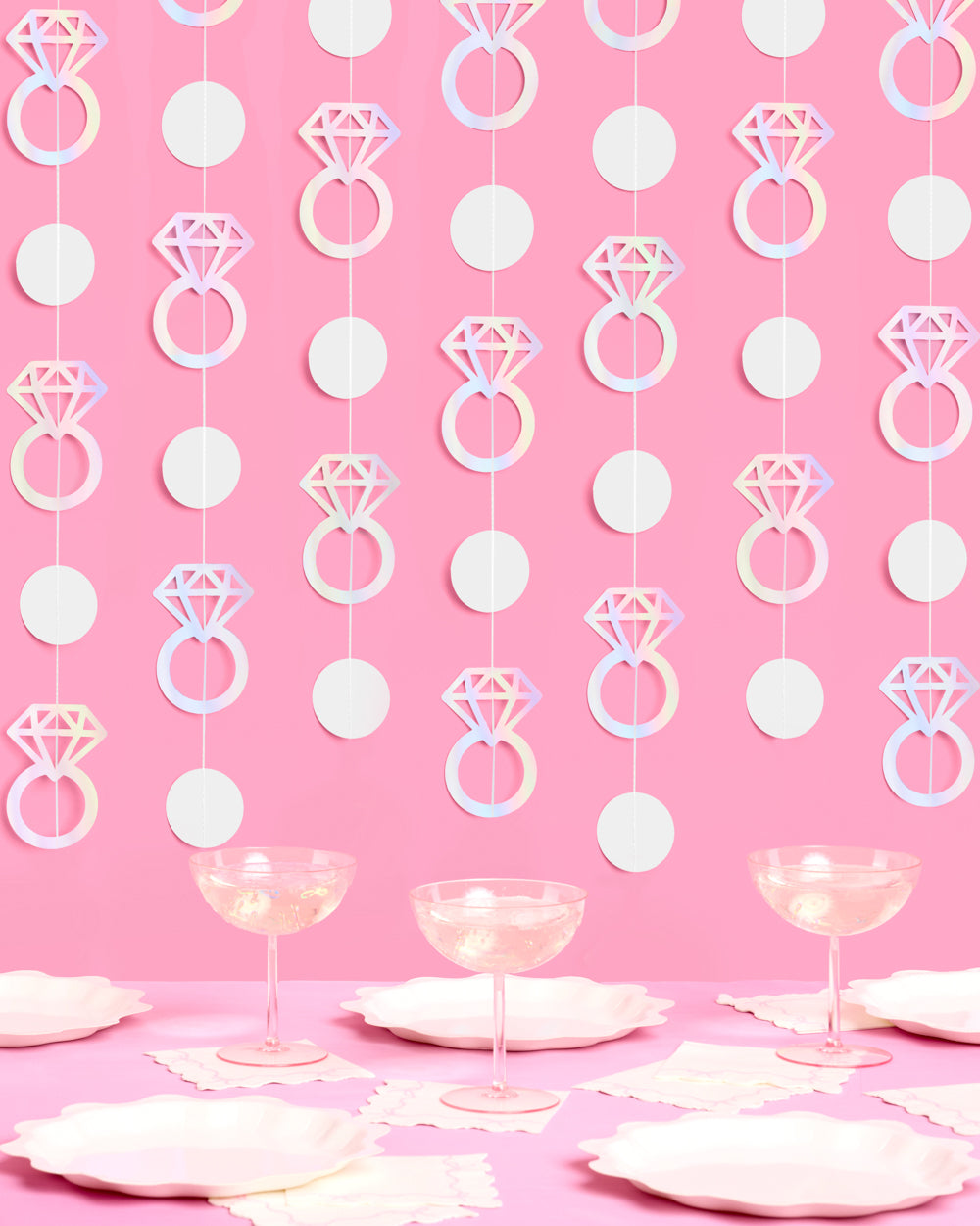 Decorative string with diamond ring and circle patterns on a pink background with table settings.