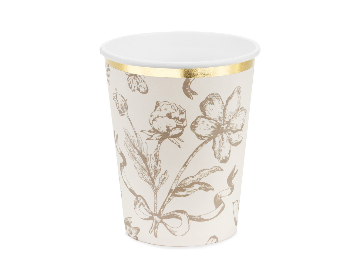 Paper cup with floral design and gold trim on a white background