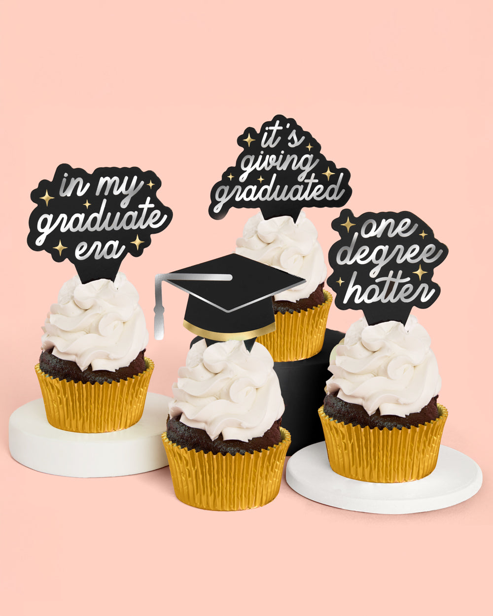Graduation-themed cupcake toppers with decorative text on a pink background