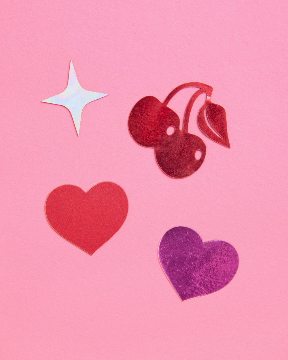 Decorative cutouts of hearts, cherries, and a star on a pink background