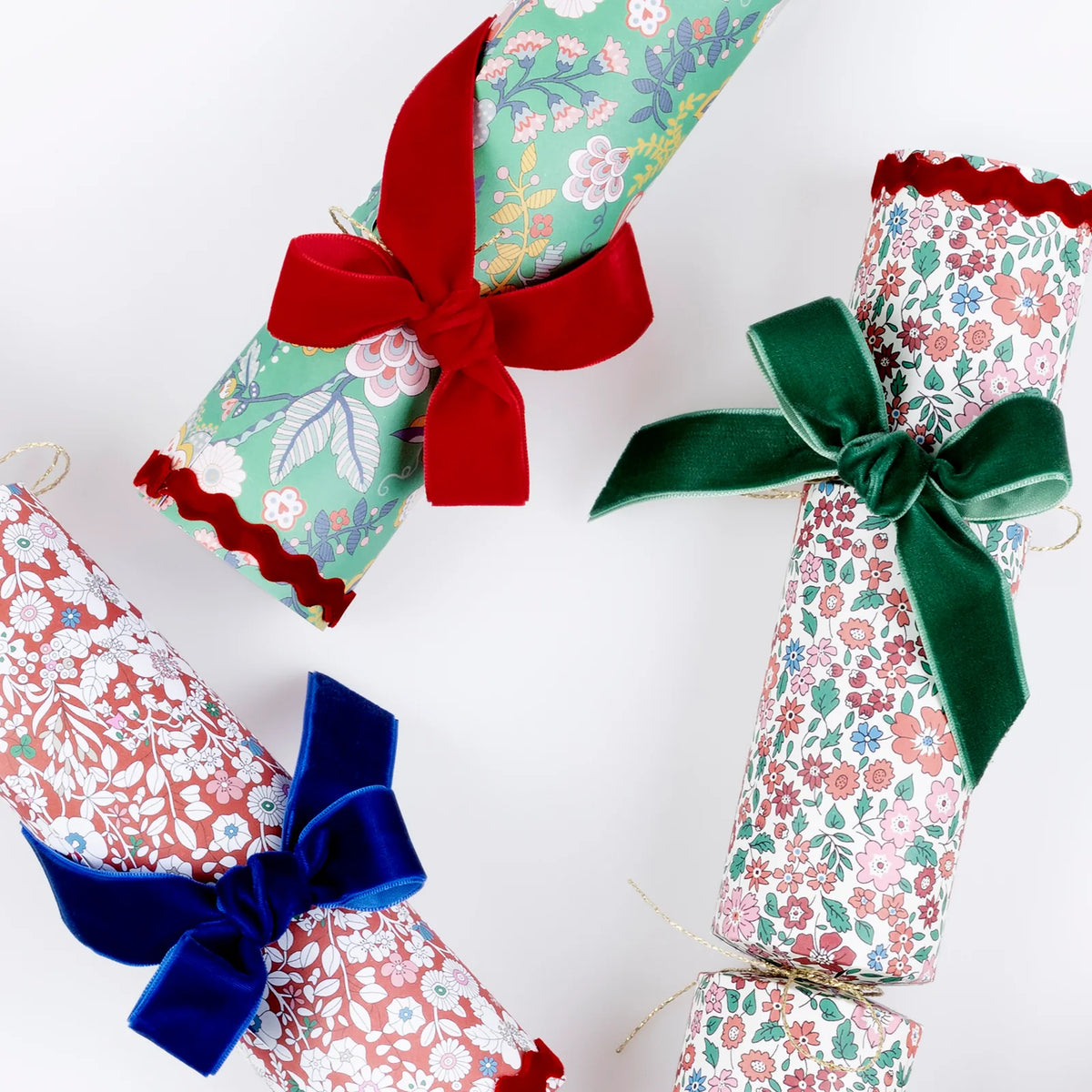 Three fabric-wrapped wine bottles with colorful bows on a white background