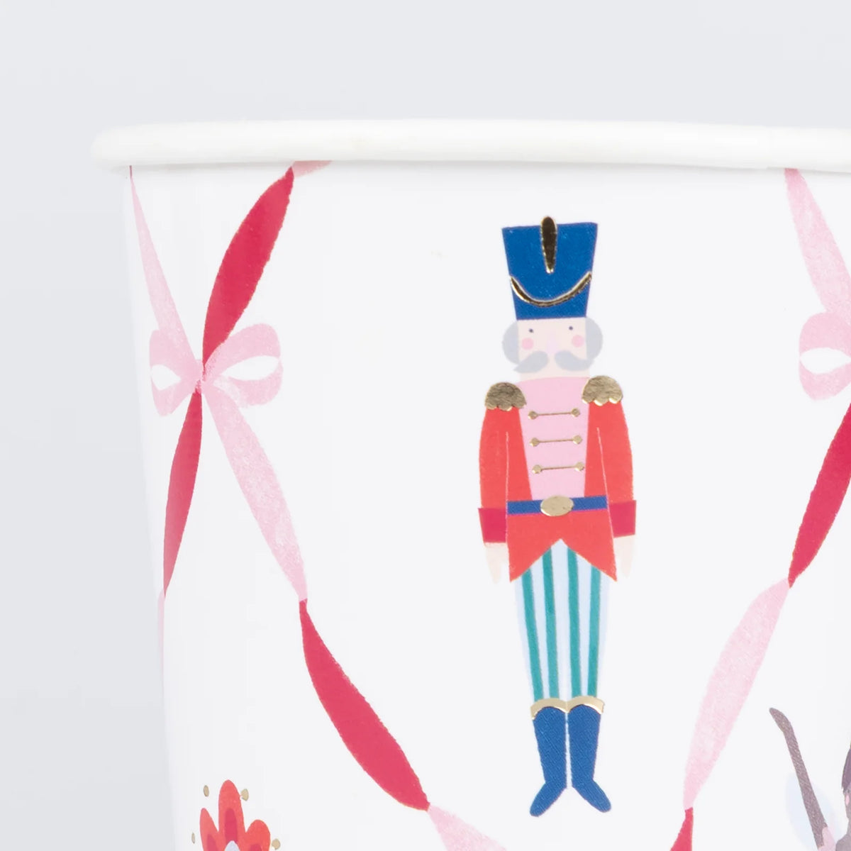 Decorative paper with a nutcracker and pink ribbons on a white background