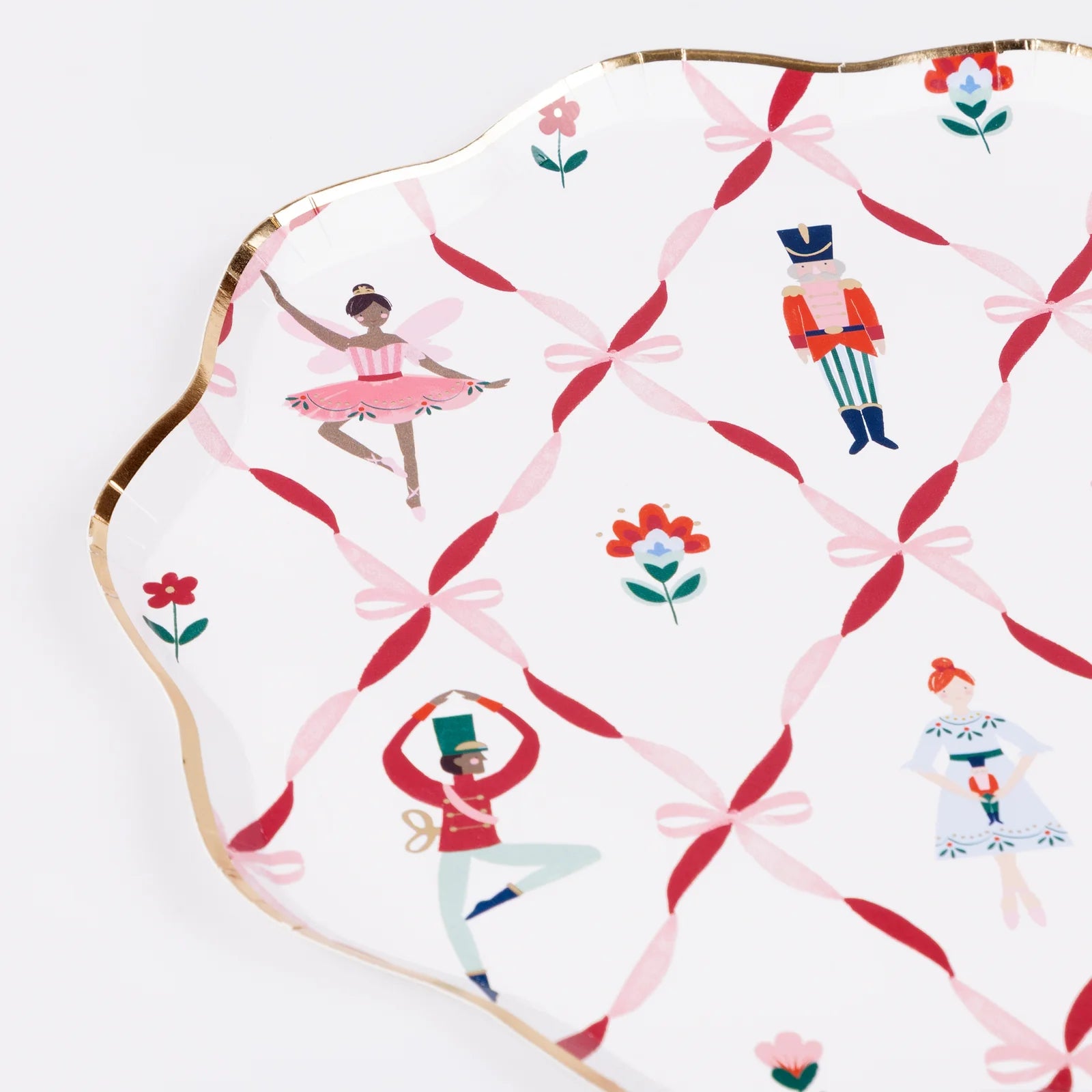 Decorative plate with ballet-themed design featuring dancers and bows on a white background.