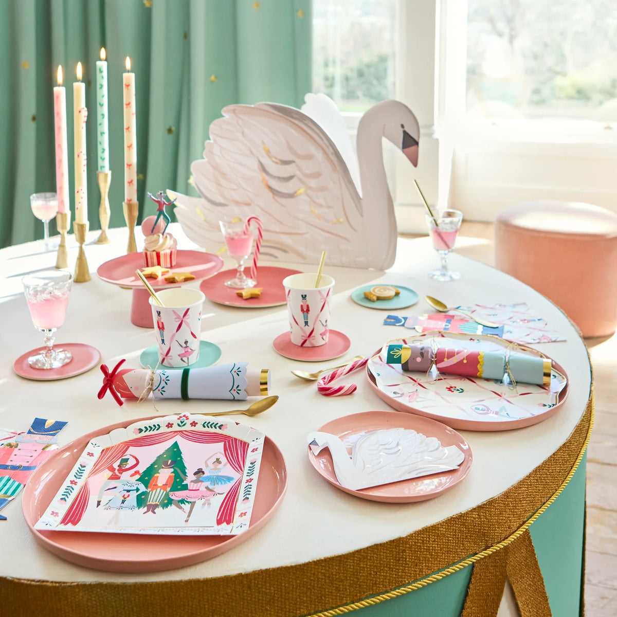 Decorative table setting with pink plates, cups, and swan centerpiece.