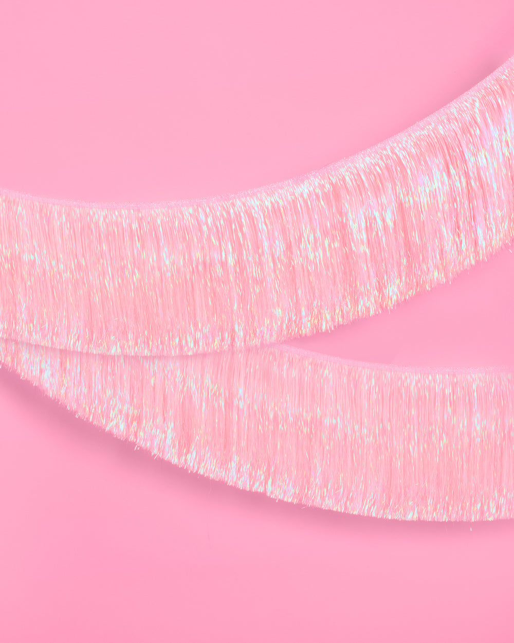 Iridescent tinsel ribbon on a pink background