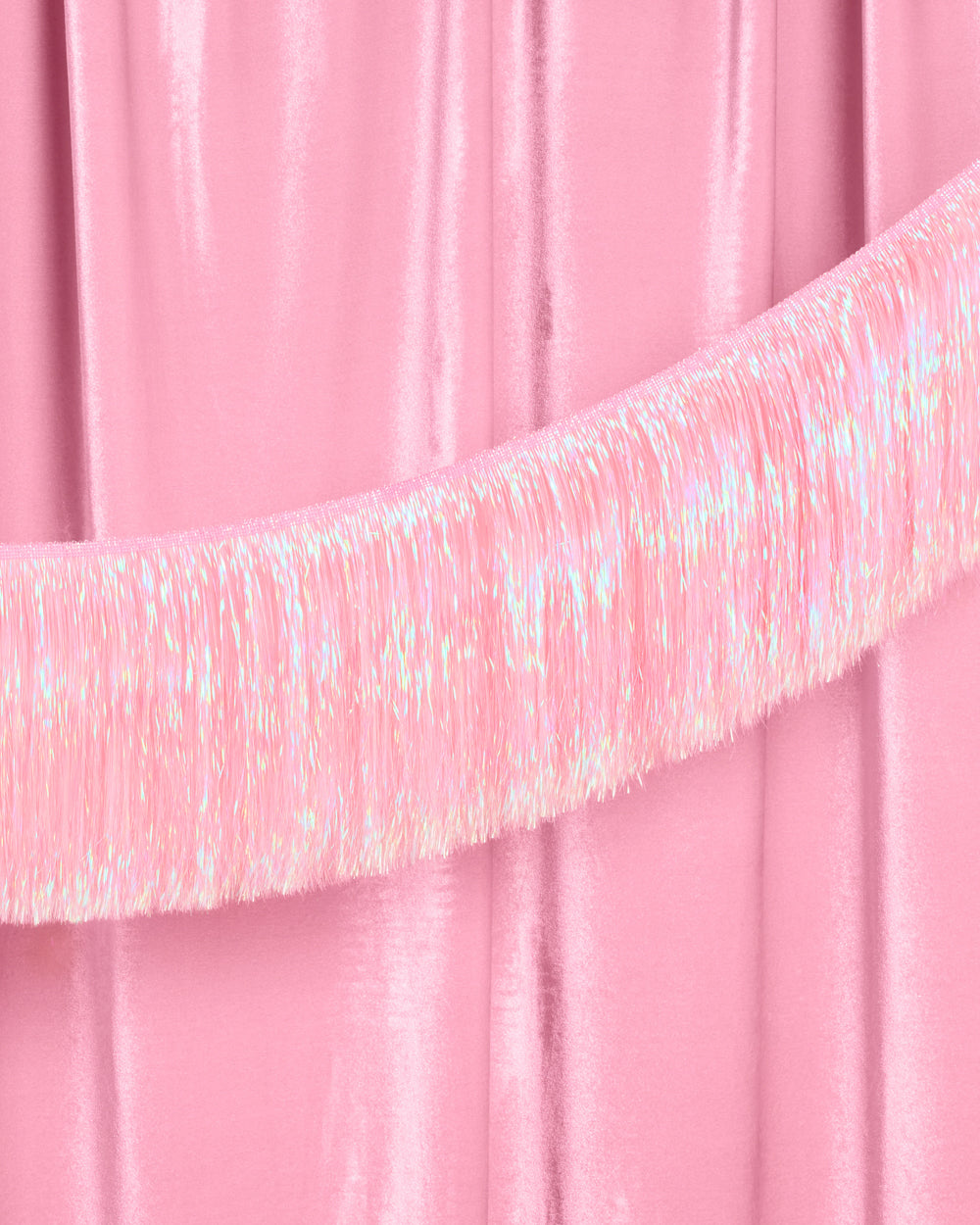 Close-up of pink tinsel on a pink curtain background
