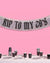 Decorative banner with 'Kiss to my 28's' text on a pink background, with a table set for a party below.