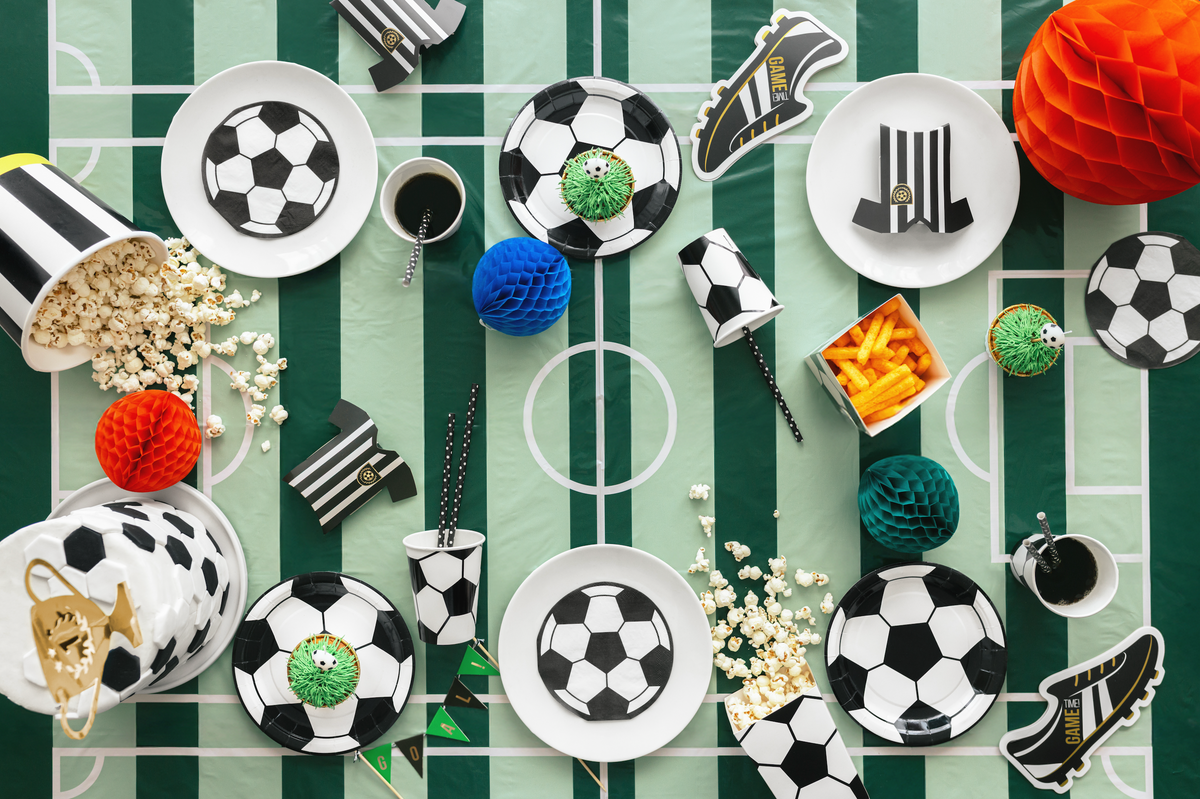 Decorative items on a tablecloth with soccer ball and sports theme