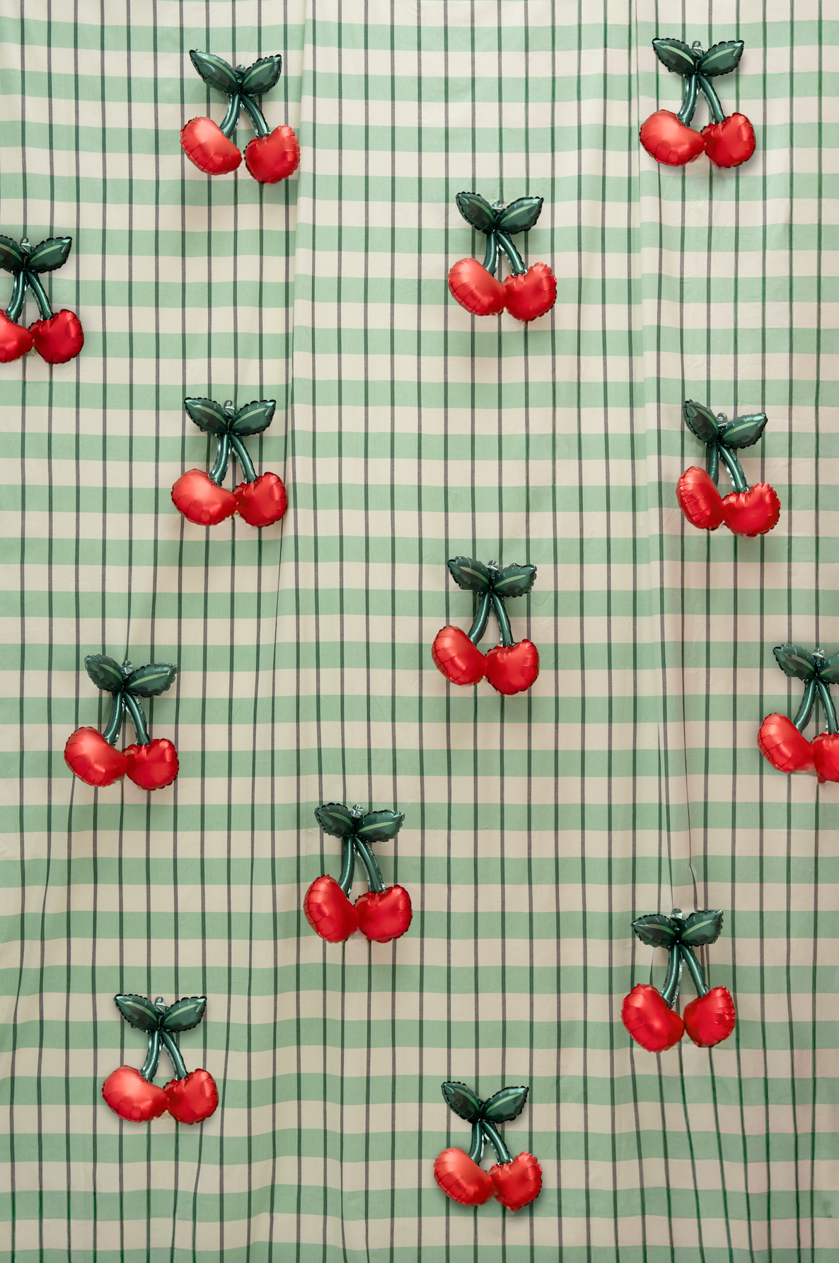 Pattern of red cherries on a green and white checkered background