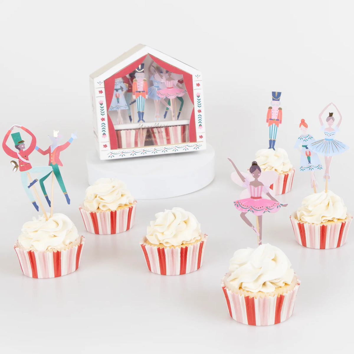 Cupcakes with ballerina-themed toppers and a Nutcracker scene in the background.