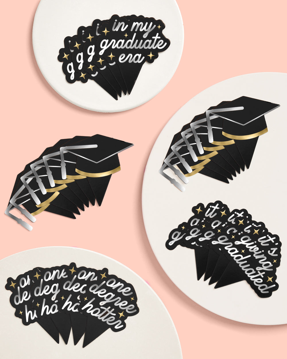 Graduation-themed coasters with decorative text and designs on a pink background