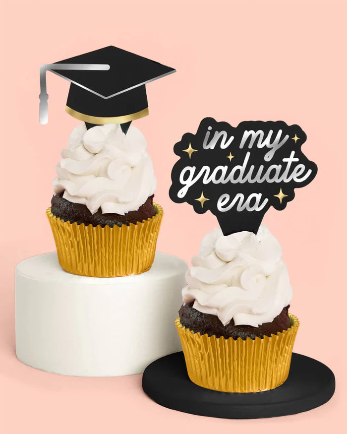 Graduation-themed cupcake toppers with decorative text on a pink background