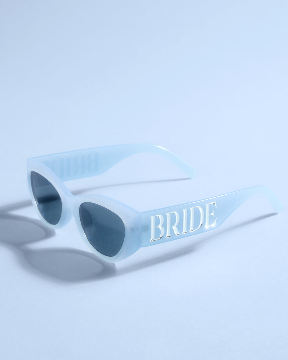 Light blue sunglasses with &#39;BRIDE&#39; text on a light blue background