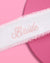 White sash with 'Bride' embroidery on a pink background