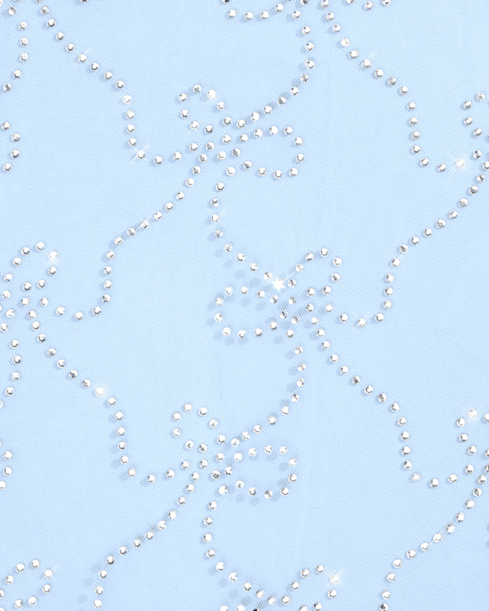 Woman wearing a white veil with floral patterns against a clear blue sky